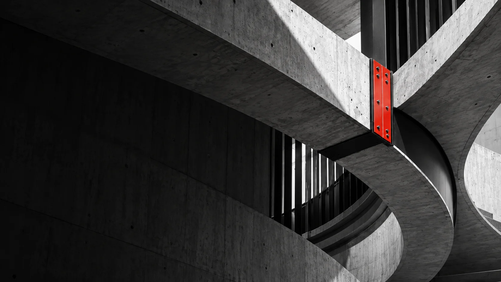 Architectural concept of sculptural concrete forms joined by a red steel connection